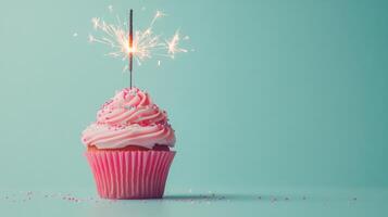 Sparkling cupcake with pink frosting on a blue background for celebration purposes photo