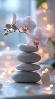 Balanced stones with pink orchids on reflective surface in tranquil setting by water photo