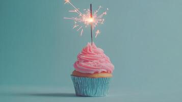Sparkling cupcake with pink frosting on a blue background for celebration purposes photo