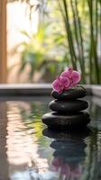 Relaxing spa setting with stacked stones and orchids in tranquil water photo