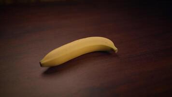 A Fresh Banana resting on a Wooden Table, highlighting its vibrant color and organic nature video