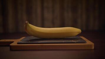 An Elegant Banana is beautifully displayed on a Slate Cutting Board in Soft, Ambient Lighting video