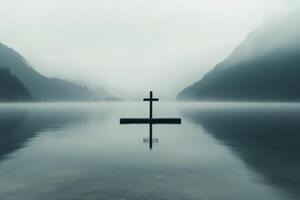 Reflections on calm waters with a cross in the distance at dawn photo