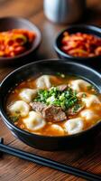 Delicious bowl of beef and dumpling soup with green onions and side of spicy dish photo
