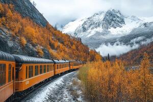 Train moving through colorful autumn forest and snowy mountains in alaska photo