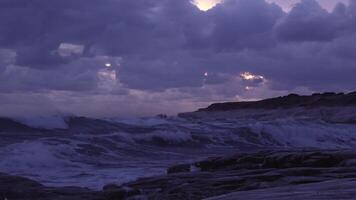 Storm waves crashing rocks coast. Dramatic skies in the evening. 4K video