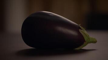 A Fresh Eggplant is beautifully displayed on a Table, illuminated by Natural Lighting video