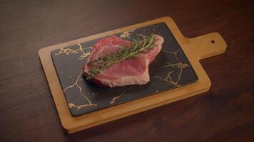 A delicious array of fresh meat on a slate board, garnished with fragrant herbs video