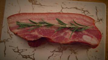 A Freshly Prepared Bacon Slice Complemented with a Rosemary Garnish on a Marble Background video