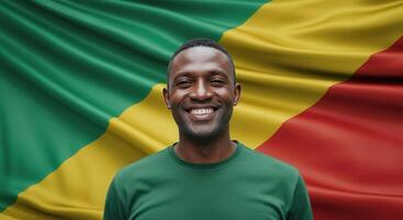 Portrait of a smiling man in green shirt in front of african flag for cultural diversity concept photo