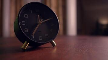 An Elegantly Designed Black Table Clock Thoughtfully Positioned on a Beautiful Wooden Surface video