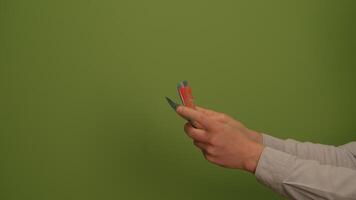 Handing Over an Object in Front of a Bright Green Background for Captivating Imagery video