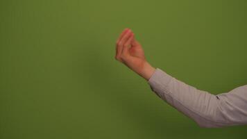 A hand gesture stands out against a vivid green background, creating an impressive visual video