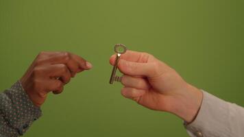 A hand is gripping a key set against a vibrant green background that adds depth and context video
