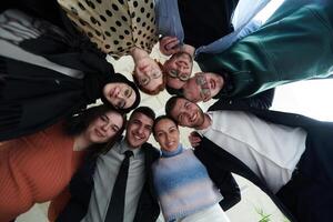 A diverse group of business professionals standing together in a powerful, united pose, captured from a low-angle perspective, exuding confidence and teamwork photo