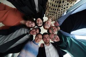 A diverse group of business professionals standing together in a powerful, united pose, captured from a low-angle perspective, exuding confidence and teamwork photo