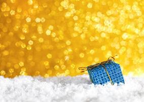 Christmas or New Year gift box on white snowy background. Close-up. Copy space. Concept of congratulations for Christmas and New Year. photo