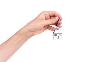 Woman's hand holds the keychain with house isolated on white background. Purchase or rent of apartments. photo