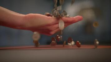 A Hand Dropping Coins in an Artistic Soft Focus Setting for a Unique Visual Experience video