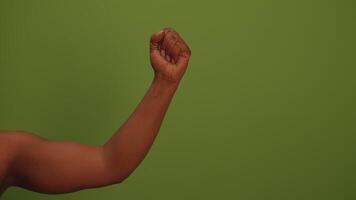 This artwork features a vibrant green background complemented by a partial view of an arm video