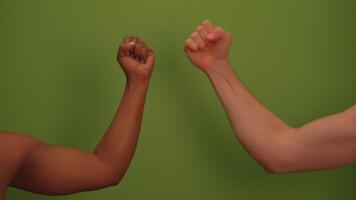 A diverse group of arms poses together for a strong display against a green background video