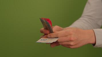 Hands Gently Holding a Card Against a Vibrant Green Background for Various Transactions video