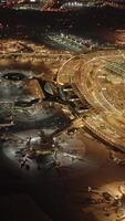 Aerial nighttime shot of bustling activity at a busy airport runway and terminal complex video