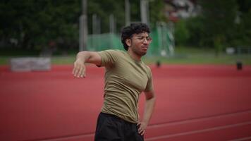 An Athlete Engaging in Stretching Exercises on the Track Field During a Training Session video