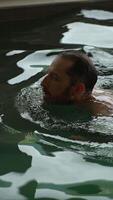 A man is swimming in a pool, enjoying a moment of perfect relaxation and fitness combined video