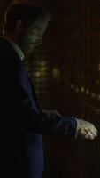 A man in a sophisticated suit holds a camera in soft, dim lighting, creating intrigue video