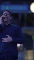 A man is engaging in an animated conversation during the night in the city environment video