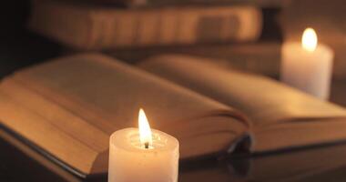 antiguo libro y soplo fuera un vela. leyendo y enseñando por luz de una vela a noche. video