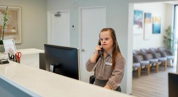 Professional receptionist in office setting emphasizing diversity and digital communication photo