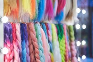 Artificial material for braiding pigtails. A colored kanekalon hangs on the wall, different materials for Afro-pigtails with space for copying photo