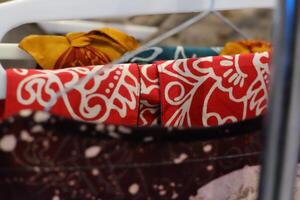 An array of Indonesian batik shirts and batik cloth hangs on the racks, displaying a variety of patterns and colors. photo