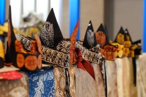 An array of Indonesian batik shirts and batik cloth hangs on the racks, displaying a variety of patterns and colors. photo