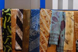 An array of Indonesian batik shirts and batik cloth hangs on the racks, displaying a variety of patterns and colors. photo
