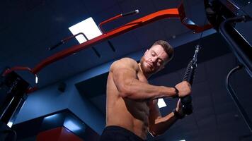 Exercise for triceps in the gym. Muscular man working out in gym doing exercises at triceps video