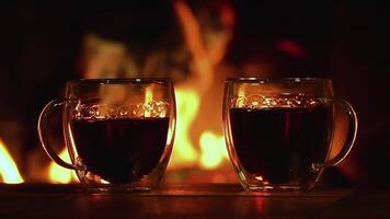 Glass cups with tea. Burning fire in the fireplace. Warmth and home comfort. Flame of a country house. Slow motion video