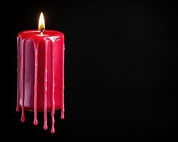 Dripping red candle on black background photo