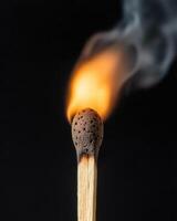 Burning match against a dark background photo