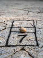 Pebble on cracked concrete with tic tac toe grid photo
