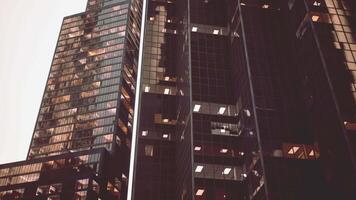 A towering skyscraper with an array of windows illuminating the city skyline video