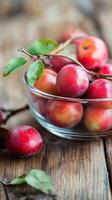 Branches in a glass container with fruit on a wooden dining table, wallpaper photo