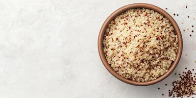 Close-up view of quinoa grains in a deep, round bowl with visible ingredients on top, meal photography photo