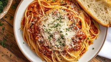Plate of spaghetti noodles topped with marinara sauce and grated cheese, served with garlic bread, culinary photography photo