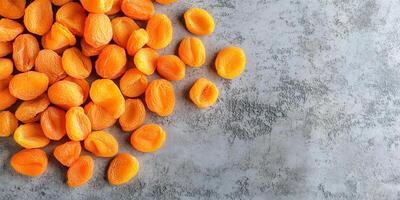 Top view of dried apricots scattered on a smooth surface, food photography photo