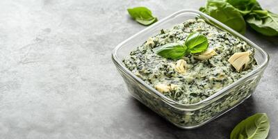 Spinach artichoke dip in a transparent dish with minimalistic presentation, culinary photography photo