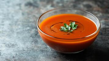 Tomato bisque soup served in a glass bowl with a smooth surface, culinary photography photo