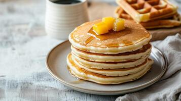 Three stacked pancakes next to two stacked waffles on separate plates, meal photography photo